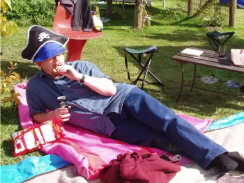 A magnificent fellow, lounging on a blanket wearing a pirate hat and drinking bourbon on New Years Eve